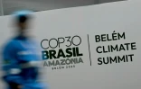 Une personne passe devant le logo de la COP30 à Belem, Brésil, le 5 novembre 2025