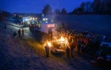 Des agriculteurs se réchauffent autour d'un feu alors qu'ils sont empêchés par les gendarmes d'entrer dans Toulouse, près de Leguevin, le 7 janvier 2026 