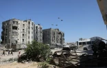 Des Palestiniens courent vers un lieu de chute des colis d'aide humanitaire largués par un avion militaire près de Jabalia, dans le nord de la bande de Gaza, le 20 août 2025
