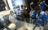 Des visiteurs découvrent des trésors restitués par la France au Bénin lors d'une exposition à Cotonou, le 20 février 2022 
