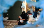 Une Palestinienne tient un enfant dans ses bras dans un camp de déplacés à Khan Younès, dans le sud de la bande de Gaza, le 11 juillet 2024