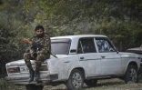 Un volontaire assis sur une voiture dans un village au sud-ouest de Stepanakert, le 23 octobre 2020