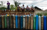 Des gens attendent pour remplir des bouteilles d'oxygène pour leurs proches atteints de Covid-19, à Mandalay le 13 juillet 2021