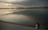 Une femme ramasse des ordures recyclables près du Pont de l'Amitiés sur le fleuve Yalu, à Dandong, le 5 juillet 2017