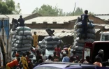 Des sacs de charbon déchargés sur le marché de la localité nigériane de Jibia, fontalière du Niger, le 18 février 2024