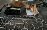 Nettoyage d'un vitrail pendant sa restauration à l'école-atelier de La Havane, le 26 octobre 2023 à Cuba