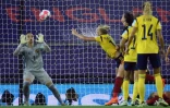 La gardienne belge Nicky Evrard (g) sauve un ballon de la tête de la Suédoise Stina Blackstenius en quart de finale de l'Euro, le 22 juillet 2022 à Leigh, près de Manchester    