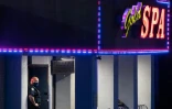 Un policier devant un salon de massage où trois personnes ont été tuées dans une fusillade le 16 mars 2021 à Atlanta en Géorgie