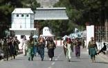 Des combattants talibans marchent devant la principale entrée de l'aéroport de Kaboul, le 28 août 2021