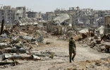 Un soldat syrien marche au milieu de ruines dans la localité de Jobar dans la Ghouta orientale, le 2 avril 2018
