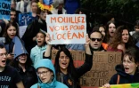 Une manifestante tient une pancarte portant les mots "Mouillez vous pour l'océan" lors de la Journée mondiale de l'océan à Paris, le 8 juin 2019