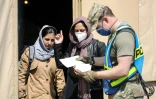 Un soldat américain parle avec des réfugiées afghanes arrivant sur la base aérienne américaine de Ramstein, en Allemagne, le 26 août 2021