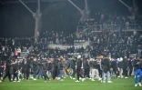 Des supporters entrés sur le terrain du stade Charléty de Paris à la mi-temps du 32e de finale de Coupe de France entre le Paris FC et Lyon le 17 décembre 2021, arrêté définitivement en raison d'incidents en tribunes