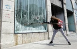 Un manifestant libanais détruit la façade d'une banque à Tripoli, dans le nord du Liban, le 28 avril 2020