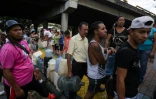 Des habitants font la queue pour s'approvisionner en eau potable, le 10 mars 2019 à Caracas