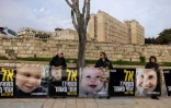 Des proches d'otages israéliens à Gaza tiennent des photos d'une mère et de ses deux enfants encore captifs, lors d'une manifestation devant le bureau du Premier ministre à Jérusalem, le 3 février 2025