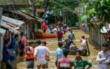 Des habitants dans une rue inondée de Feni, le 23 août 2024 au Bangladesh