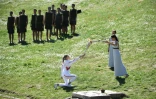 La Grecque Anna Korakaki (à genou), reçoit la torche de la flamme olympique, lors d'une cérémonie officielle devant une poignée de spectateurs à Olympie, le 12 mars 2020 