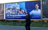 Une femme passe devant une affiche électorale du candidat à la présidence du parti de l'Union démocratique croate (HDZ), Dragan Primorac, dans le centre de Zagreb, le 27 décembre 2024