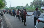 Des Indiens sans domicile fixe et qui ont pour la plupart perdu leur emploi font la queue lors d'une distribution de nourriture Ă New Delhi le 20 mai 2021