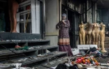 Une propriétaire devant sa boutique incendiée et vandalisée au lendemain de manifestations violentes marquant les commémorations du premier anniversaire de la prise du Parlement, le 26 juin 2025 à Nairobi, au Kenya