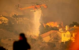 Un hélicoptère largue de l'eau pour tenter de stopper l'incendie baptisé "Saddleridge Fire" qui progresse à une vingtaine de km au nord de Los Angeles, le 11 octobre 2019