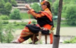 Une femme kalash en habit traditionnel tisse devant chez elle à Bumburate au Pakistan, le 17 mai 2019