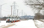 Des camions d'une compagnie d'électricité garés le long d'une route enneigée à Fort Worth, au Texas, le 16 février