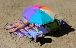 Une femme prend un bain de soleil sur une plage de Benidorm, en Espagne, le 10 septembre 2025
