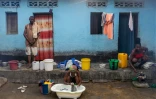 Une femme fait la lessive avec de l'eau puisée dans un puits le 14 juillet 2023, à Selembao, un quartier pauvre à la périphérie de Kinshasa, où l'accès à l'eau est difficile. 
