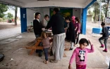 Des réfugiés du camp de Ritsona, au nord d'Athènes, reçoivent un repas préparé par le chef cuisinier syrien Talal Rankoussi, le 21 décembre 2016 en Grèce