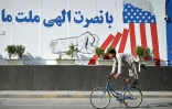 Un cycliste afghan exécute une figure en passant devant une fresque murale proclamant « Avec l'aide divine, notre nation a vaincu l'Amérique », à Kaboul, le 15 août 2026, alors que le gouvernement taliban célèbre le cinquième anniversaire de son retour au pouvoir. Le gouvernement taliban marque ce 15 août ses cinq années à la tête de l'Afghanistan ; les autorités vantent la « liberté » et la sécurité du pays, tandis que les critiques dénoncent un durcissement des restrictions dans tous les aspects de la vie quotidienne
