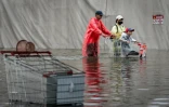 Des habitants dans une rue de Bangkok, où l'état de catastrophe naturelle a été déclaré après des pluies diluviennes qui ont inondé habitations, commerces et axes de circulation, le 27 septembre 2026
