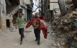 Un Palestinien porte le corps d'une victime à Choujaïya à Gaza-ville, le 9 avril 2025