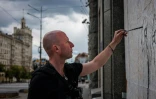 Le street artiste ukrainien Galmet Zinkivsky en train de peindre à Kharkiv, dans l'est de l'Ukraine, le 16 mai 2022