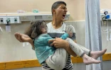 Un Palestinien transporte une fille blessée lors de frappes israéliennes à Khan Younès, à l'hôpital Nasser dans le sud de la bande de Gaza, le 3 juin 2025