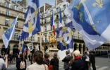 Des manifestants tiennent des drapeaux lors d'une manifestation à l'appel de l'organisation catholique intégriste Civitas devant la statue de Jeanne d'Arc, le 8 mai 2016 à Paris
