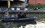 La police patrouille sur un zodiac lors de l'évacuation du campement de migrants du Millénaire, à Paris, le 30 mai 2018