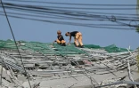 Des pompiers sur le site d'un immeuble effondré lors d'opérations de recherche et de sauvetage à Angeles City, dans la province de Pampanga, au nord de Manille, le 25 mai 2025 aux Philippines