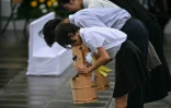 Des élèves réalisent un rituel avec des seaux d'eau comme offrandes, le 9 août 2025 à Nagasaki pour marquer les 80 ans du bombardement atomique de la ville