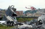 Un hélicoptère des sauveteurs survole une section du viaduc de l'A10 après son effondrement, le 14 août 2018 à Gênes, dans le nord de l'Italie