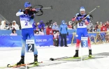 Le Français Quentin Fillon-Maillet tire au côté du Russe Eduard Latypov, lors de la poursuite aux Jeux de Pékin, le 13 février 2022 au centre national de biathlon de Zhangjiakou