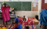 Des personnes touchées par le cyclone Chido attendent avant une distribution de nourriture à l'école primaire Paulette Henry dans la ville de Mamoudzou, sur l'archipel français de Mayotte dans l'océan Indien, le 29 décembre 2024