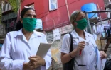 La docteure cubaine Liz Caballero (g), avec une étudiante font du porte à porte dans le quartier du Vedado, le 31 mars 2020 à La Havane, pendant l'épidémie de coronavirus à Cuba