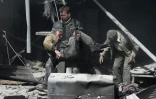 Un homme au secours d'un blessé après les bombardements du régime syrien contre la ville rebelle de Hammouriyé, le 19 février 2018