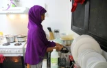 Une réfugiée de Somalie qui a tenté plusieurs fois de se suicider effectue des tâches ménagères dans une cuisine du camp numéro 5 sur l'île de Nauru, le 2 septembre 2018