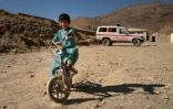 Un enfant à vélo devant la clinique de Tangi Saidan,  le 6 octobre 2021 dans le centre de l'Afghanistan