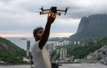 Le pilote de drone Pedro Lucas récupère son drone après avoir filmé un touriste pour les réseaux sociaux au célèbre point de vue touristique "Porta do Ceu" (Porte du Ciel) dans la favela de Rocinha, à Rio de Janeiro, au Brésil, le 5 mars 2026