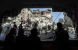 Des Palestiniens examinent les décombres de bâtiments détruits après un bombardement israélien à Rafah, dans le sud de la bande de Gaza, le 27 mars 2024