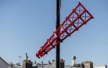 Une grue soulève l'une des quatre pales provisoires pour l'instllaer au sommet du cabaret le Moulin Rouge, le 24 juin 2024 à Paris